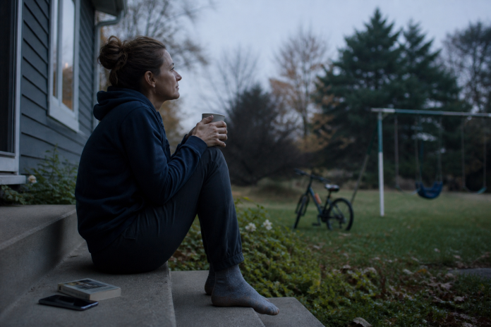 Spiritual awakening: an early morning of questions Woman sitting on back steps at dawn with a mug, looking out at a quiet garden
